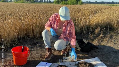 Female Agronomy Specialist Conducting Soil Acidity Test By Taking PH