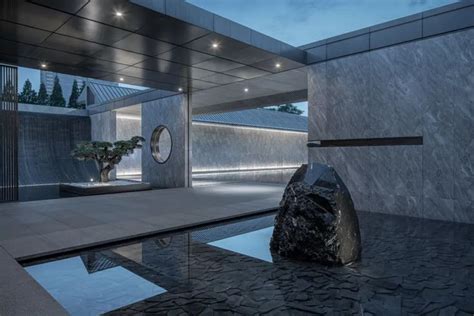 A Large Rock Sitting In The Middle Of A Pool Next To A Building With