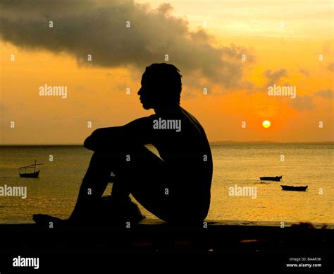 Youth Sitting On Promenade Wall At Sunset At Porto Da Barra Beach