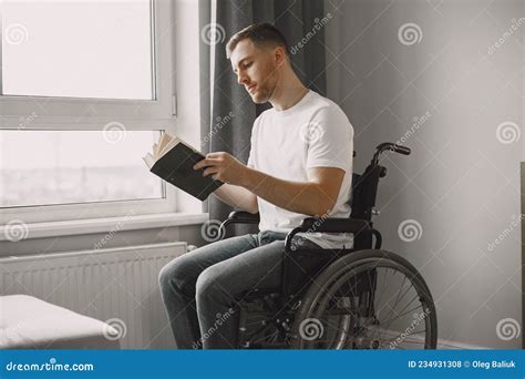 Discapacitado En Silla De Ruedas Leyendo Un Libro En Casa Foto De