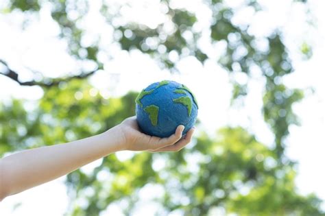 Niño joven con la mano sosteniendo el globo terrestre en el parque