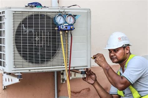 Premium Photo A Professional Electrician Man Is Fixing A Heavy Air