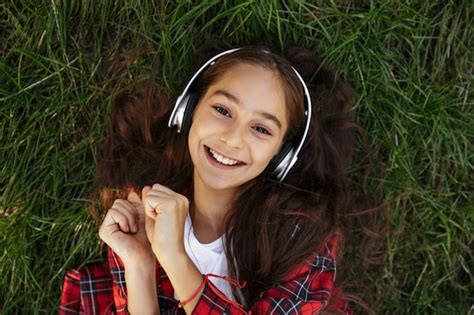 Vue De Dessus De La Souriante Jeune Fille Brune Allongée Sur Lherbe