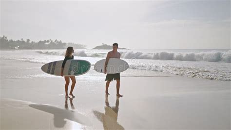 Surfers In Swimwear Paddling On Surfboards Man Woman In Swimsuit Swim