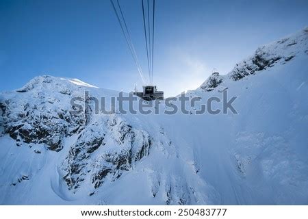 Ski Lift Carrying Skiers Up To The Clear Blue Sky Stock Image