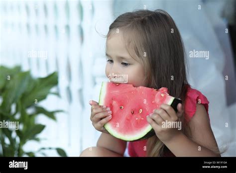 Adorable Blonde Girl Eats A Slice Of Watermelon Outdoor Stock Photo Alamy
