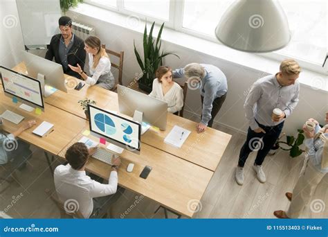 Office Employees Working Together Sharing Desk Using Computers I Stock