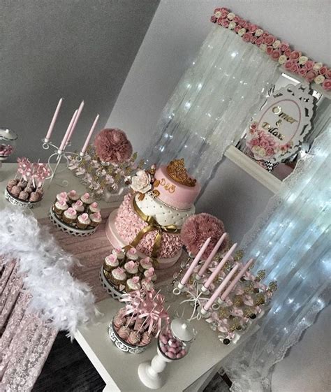 A Table Topped With Lots Of Pink And White Cupcakes Next To Cake