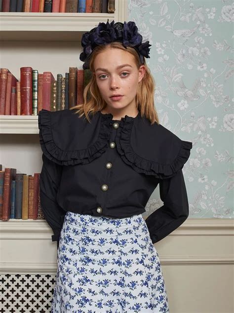 Black Blouse With Large Peter Pan Collar Accented With Faux Pearl Buttons