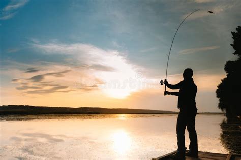 A Fisherman Silhouette Fishing At Sunset Freshwater Fishing Catch Of