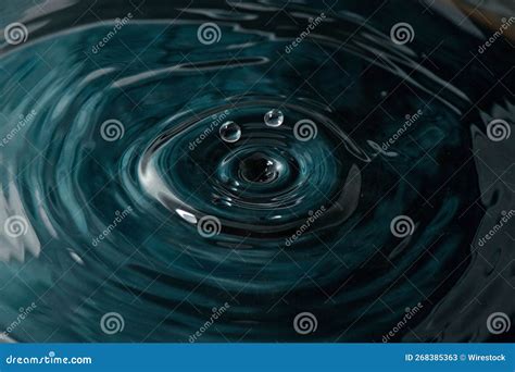 Closeup Of Two Droplets Falling Into The Rippling Water Stock Image