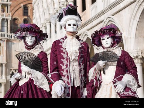 Three masked people wearing red and white carnival costumes, Carnevale ...