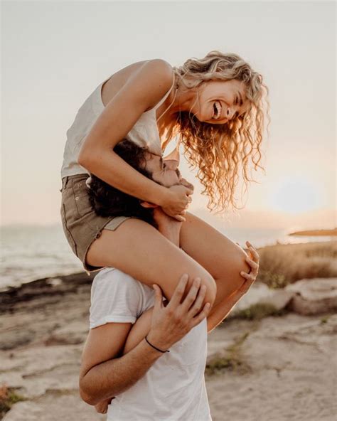 A Man Carrying A Woman On His Back At The Beach