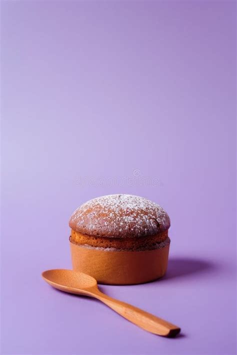 Powdered Sugar Dusted Chocolate Muffin With Terracotta Pot On Purple