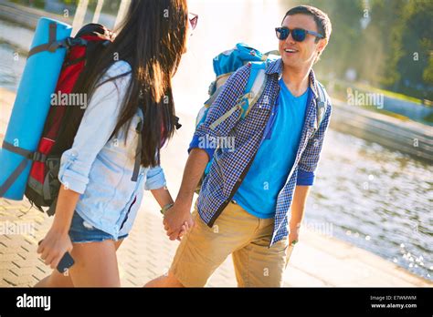 Couple of young travelers talking while taking walk in a city Stock ...