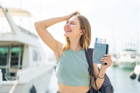 Junge blonde Frau draußen einen Reisepass hält hat etwas erkannt und beabsichtigt