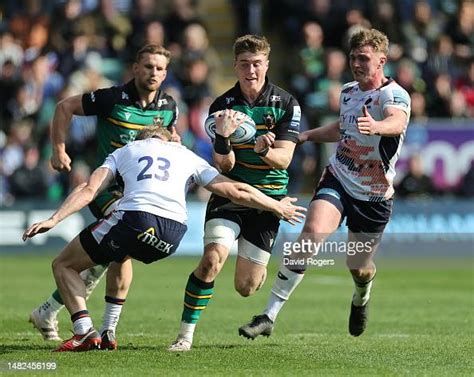 Tommy Freeman of Northampton Saints is held by Ben Harris during the ...