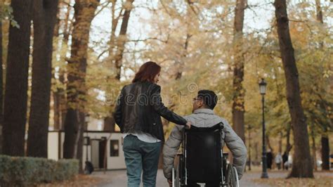 Disabled Man Pushing The Wheels Of A Wheelchair With His Own Hands And