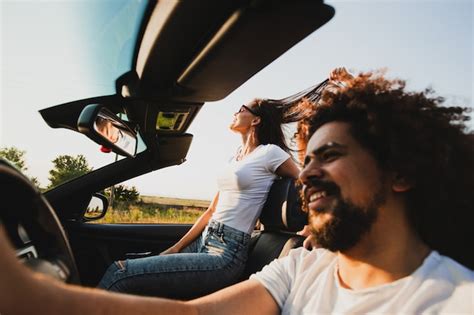 Jovem Cacheado De Cabelos Escuros Sentado Ao Volante De Um Cabriolet