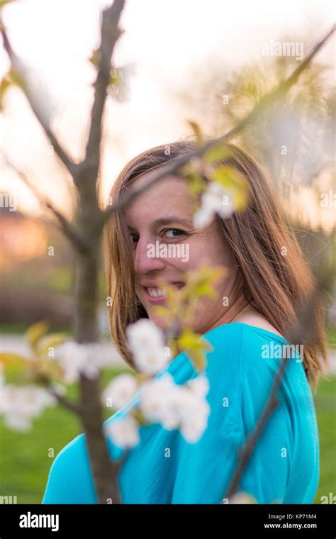 Smiling Gorgeous Brunette Hiding Behind Cherry Blossoms Stock Photo Alamy