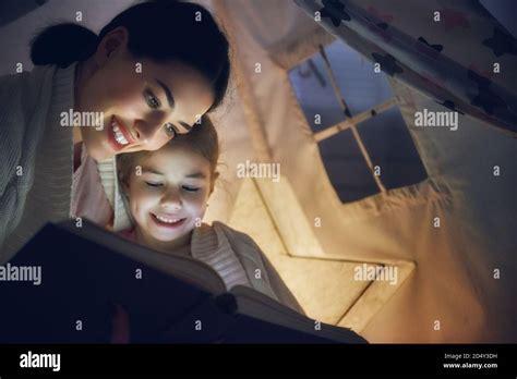 La familia a la hora de acost Mamá y su hija están leyendo un libro en