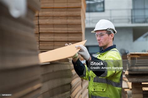 Male Warehouse Worker Working And Inspecting Quality Of Cardboard In