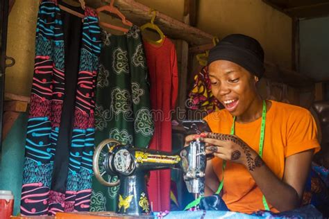 A Pretty Young African Female Tailor Smiling While Viewing Content On