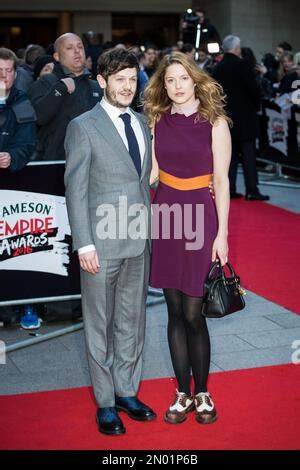 Iwan Rheon And Zoe Grisedale Pose For Photographers Upon Arrival At The