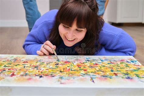 Young Woman Laughing and Painting on Canvas with Oil Paints at Home ...