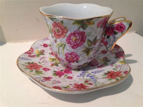 A Tea Cup And Saucer Sitting On Top Of A White Countertop Next To A Wall