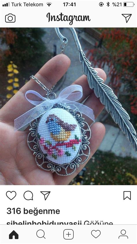 Someone Is Holding Up A Cross Stitch Ornament With A Bird In The Center