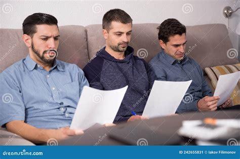 Three Serious Men Reading Papers On Sofa Stock Image Image Of