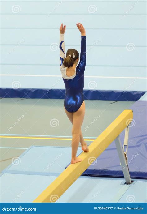 Young Gymnast Girl Performing Routine On Balance Beam Stock Image