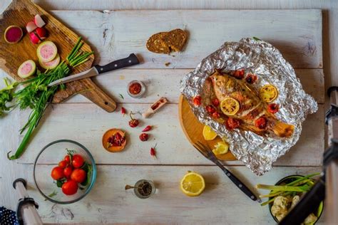 Premium Photo Baked Fish With Vegetables On The Table With Different