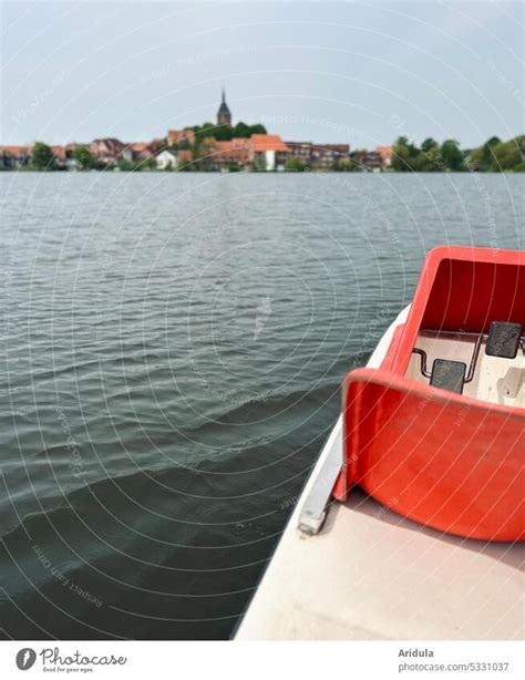 Pedal boat on a lake with small town in the background No. 2 - a Royalty Free Stock Photo from ...