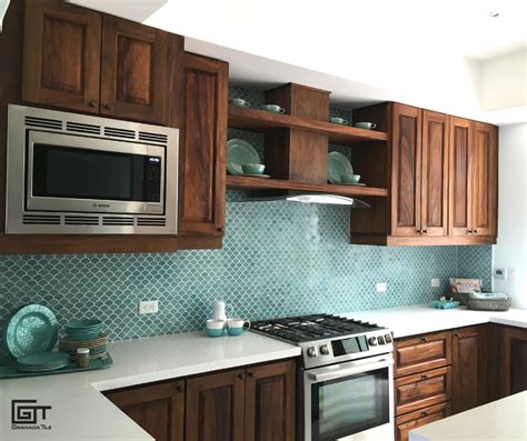 A kitchen with brown cabinets, white countertops, and a wall with scale ...