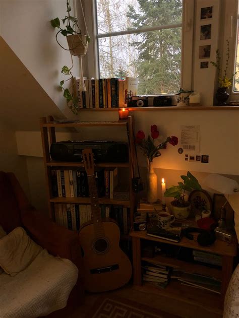 A Room With A Guitar Bookshelf And Candles On The Floor In Front Of A