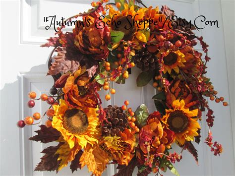 an autumn wreath with sunflowers, berries and pinecones on the front door