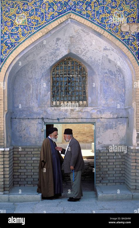 Iran, Isfahan Province, Esfahan, mollah and devotee in front of a madresseh or coranic school ...