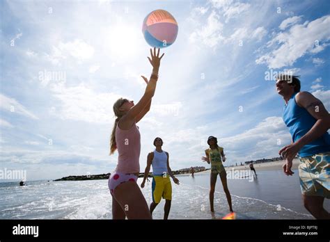 Four adults playing with a beach ball Stock Photo - Alamy