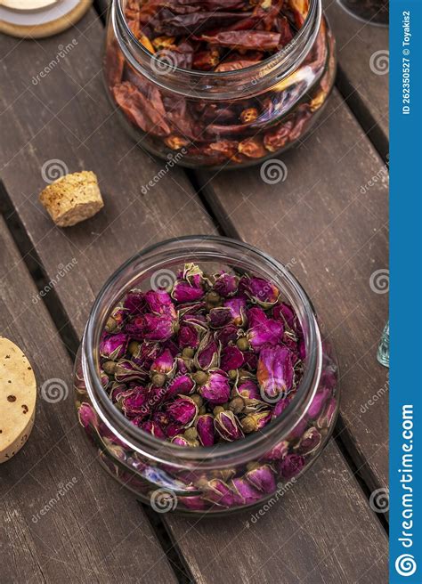 Glass Jar With Cork Lids Filled With Dried Tea Roses On Unvarnished Dark Wood Planks Stock Image