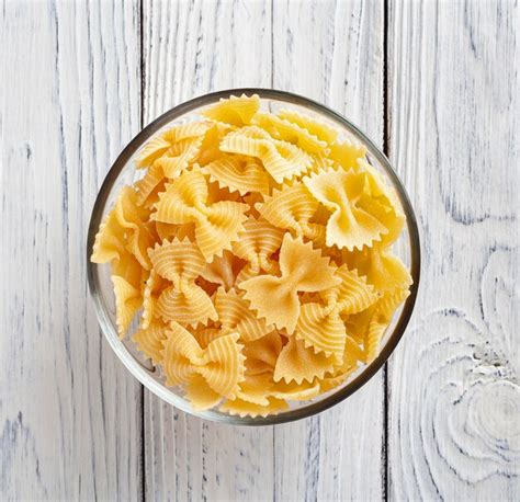 Pasta Farfalle Rigate Sin Cocer Sobre Fondo Blanco De Madera Foto Premium