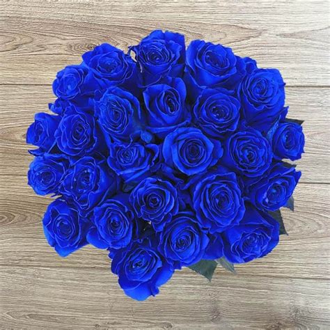 a bouquet of blue roses sitting on top of a wooden table