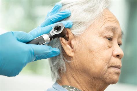 Audiologist Or Ent Doctor Use Otoscope Checking Ear Of Asian Senior