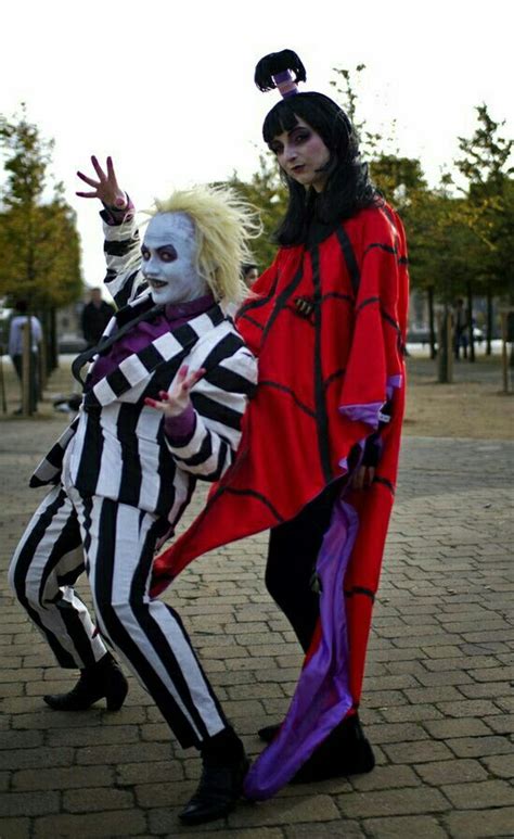 two people dressed in costumes posing for the camera on a brick walkway ...