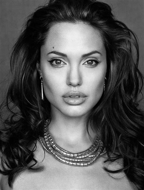 A Black And White Photo Of A Woman With Large Earrings On Her Neck