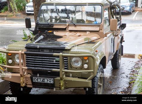 Classic Land Rover Defender 110 in army camouflage colours parked in ...