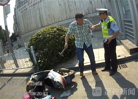 男子骑无牌摩托被查 竟然当街抡锤砸车