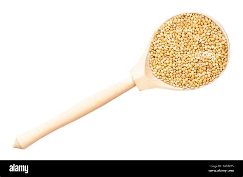 Top View Of Unpolished Yellow Proso Millet In Wood Spoon Isolated On