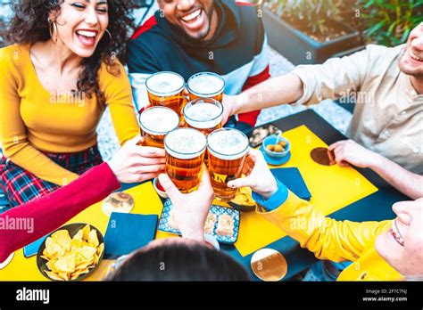 Grupo De Amigos Multiculturales Bebiendo Y Tostar Cerveza En La